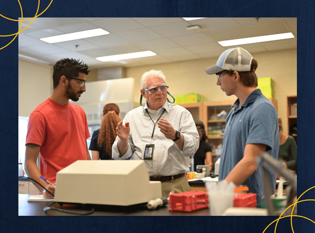 Students talking to a professor in a lab.